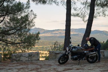 Yalnız bir adam dağ yolunda motosikletle tek başına seyahat ediyor.