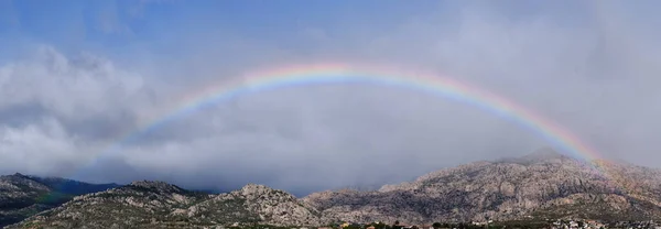 La Pedriza üzerindeki gökkuşağının panoramik görüntüsü.
