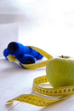 Blue Weights, Apple, and Tape Measure, diet concept