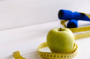 Blue Weights, Apple, and Tape Measure, diet concept