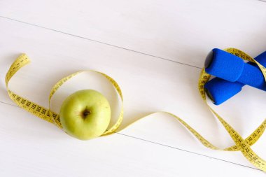 Dambıllar, taze elma ve mezura, diyet ve egzersiz kavramı.