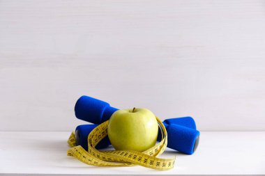 Dambıllar, taze elma ve mezura, diyet ve egzersiz kavramı.