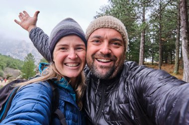 Dağlarda yürüyüş yapan mutlu bir çift, yolun sonunda başarılı yürüyüşçüler..