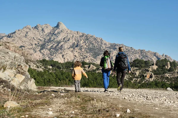 En familj som vandrar i bergen en solig dag — Stockfoto