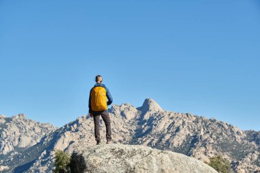Dağlarda bir kadın yürüyüşçü, doğal bir gözetleme noktasında.
