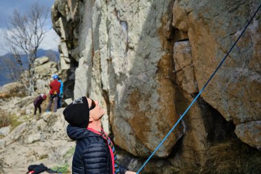 Erkek dağcı uçurumun kenarında duruyor.