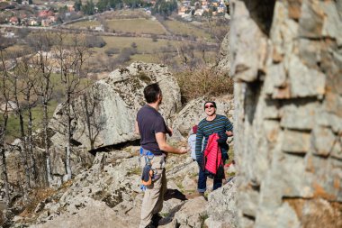 Neşeli adamlar dağlarda birlikte kayalara tırmanıyorlar.