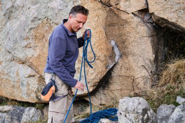 Dağcı dağlara tırmanmak için ip hazırlıyor.