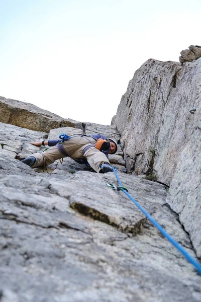 Un uomo irriconoscibile che si arrampica su una roccia a strapiombo — Foto Stock