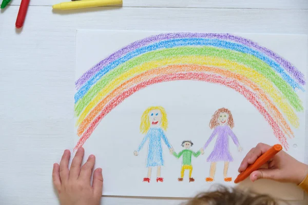 Ekin çocuk masaya LGBT ailesini çiziyor.