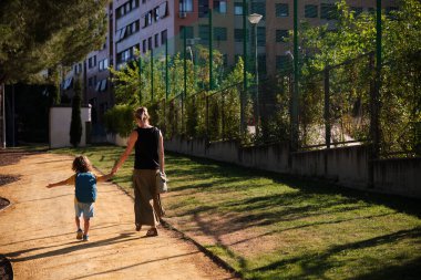 Mother and son walking to school in daily morning