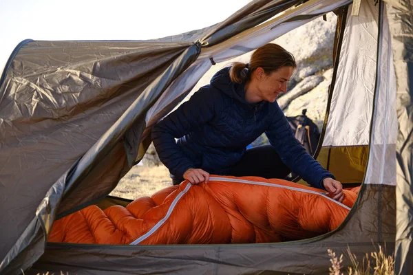 Glad Kvinna Fästa Orange Sovsäck Inne Tält Samtidigt Förbereda Sig — Stockfoto