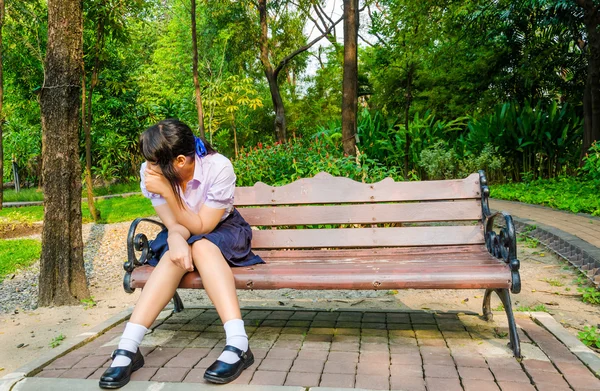 Colegiala llorando sola en el banco —  Fotos de Stock