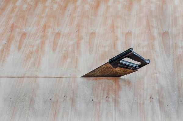 A saw is sawing through the wooden boar — Stock Photo, Image