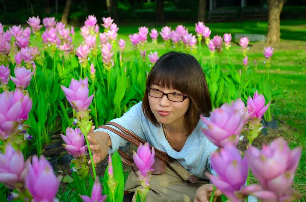 Cute girl tajski ukrywa się wśród tulipan różowy siam — Zdjęcie stockowe