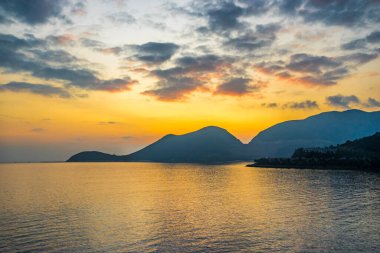 Denizin üzerinde gün batımı yalnız bir tekneyle