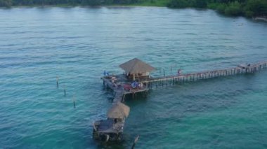 Denizde ahşap plaj barının üzerinde gün batımı ve Koh Mak adasında bir kulübe, Trat, Tayland