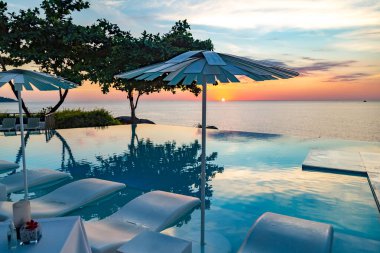 Sunset at the edge of a swimming pool at Kata beach in Phuket province, in Thailand