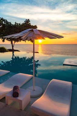 Sunset at the edge of a swimming pool at Kata beach in Phuket province, in Thailand