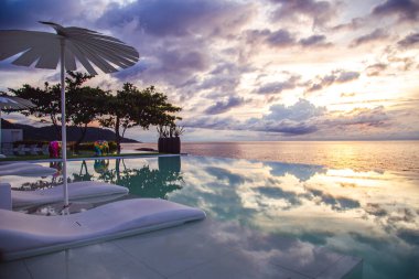 Sunset at the edge of a swimming pool at Kata beach in Phuket province, in Thailand