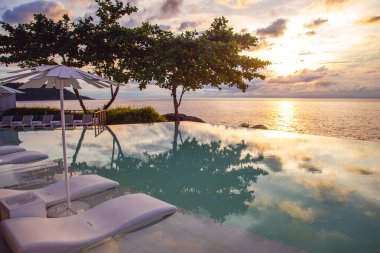 Sunset at the edge of a swimming pool at Kata beach in Phuket province, in Thailand