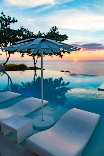 Sunset at the edge of a swimming pool at Kata beach in Phuket province, in Thailand — стоковое фото