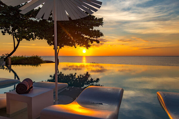 Sunset at the edge of a swimming pool at Kata beach in Phuket province, in Thailand