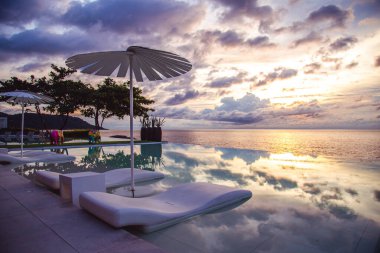 Sunset at the edge of a swimming pool at Kata beach in Phuket province, in Thailand