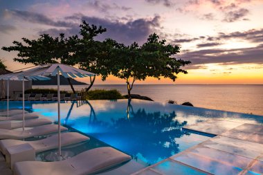 Sunset at the edge of a swimming pool at Kata beach in Phuket province, in Thailand