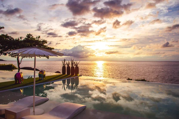 Sunset at the edge of a swimming pool at Kata beach in Phuket province, in Thailand — Stock Photo, Image