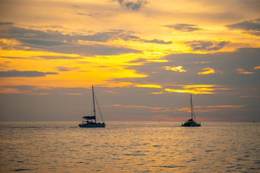 Tayland 'ın Phuket yarımadasındaki Promthep Burnu' nda gün batımında yelkenli sürüyor.