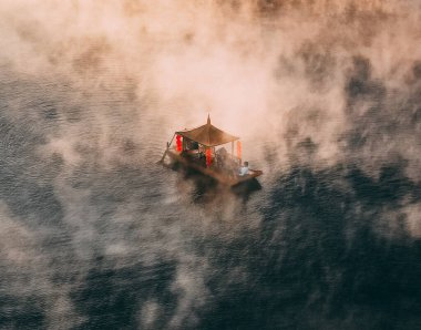 Ban Rak Thai 'de, Tayland' da Mae Hong Son 'da bir göl kenarındaki Çin köyünün üzerinde sisli gündoğumu manzarası.