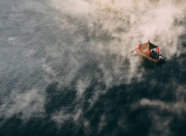 Ban Rak Thai 'de, Tayland' da Mae Hong Son 'da bir göl kenarındaki Çin köyünün üzerinde sisli gündoğumu manzarası.