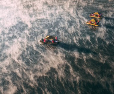 Ban Rak Thai 'de, Tayland' da Mae Hong Son 'da bir göl kenarındaki Çin köyünün üzerinde sisli gündoğumu manzarası.