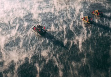 Ban Rak Thai 'de, Tayland' da Mae Hong Son 'da bir göl kenarındaki Çin köyünün üzerinde sisli gündoğumu manzarası.