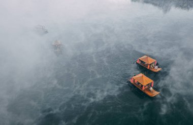 Ban Rak Thai 'de, Tayland' da Mae Hong Son 'da bir göl kenarındaki Çin köyünün üzerinde sisli gündoğumu manzarası.