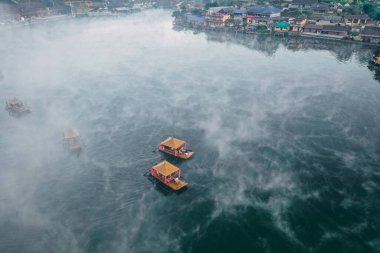 Ban Rak Thai 'de, Tayland' da Mae Hong Son 'da bir göl kenarındaki Çin köyünün üzerinde sisli gündoğumu manzarası.