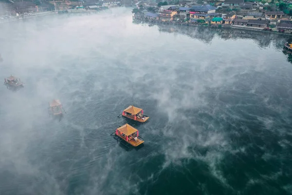 Ban Rak Thai 'de, Tayland' da Mae Hong Son 'da bir göl kenarındaki Çin köyünün üzerinde sisli gündoğumu manzarası.