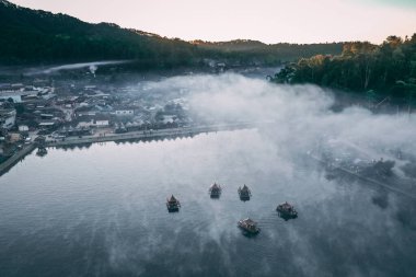 Ban Rak Thai 'de, Tayland' da Mae Hong Son 'da bir göl kenarındaki Çin köyünün üzerinde sisli gündoğumu manzarası.