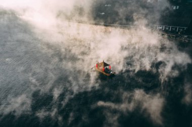 Ban Rak Thai 'de, Tayland' da Mae Hong Son 'da bir göl kenarındaki Çin köyünün üzerinde sisli gündoğumu manzarası.