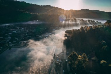 Ban Rak Thai 'de, Tayland' da Mae Hong Son 'da bir göl kenarındaki Çin köyünün üzerinde sisli gündoğumu manzarası.