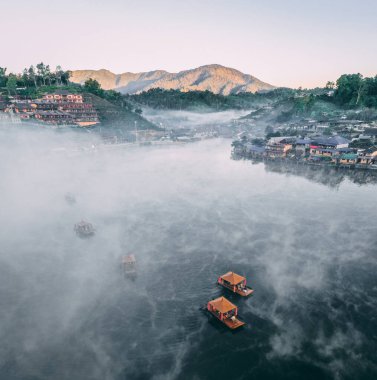 Ban Rak Thai 'de, Tayland' da Mae Hong Son 'da bir göl kenarındaki Çin köyünün üzerinde sisli gündoğumu manzarası.