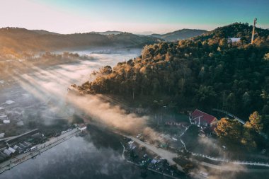 Ban Rak Thai 'de, Tayland' da Mae Hong Son 'da bir göl kenarındaki Çin köyünün üzerinde sisli gündoğumu manzarası.
