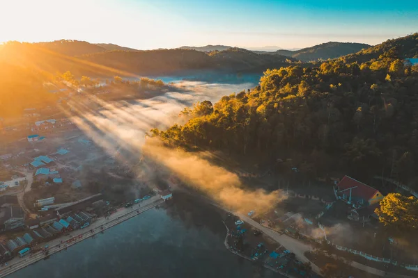 Ban Rak Thai 'de, Tayland' da Mae Hong Son 'da bir göl kenarındaki Çin köyünün üzerinde sisli gündoğumu manzarası.