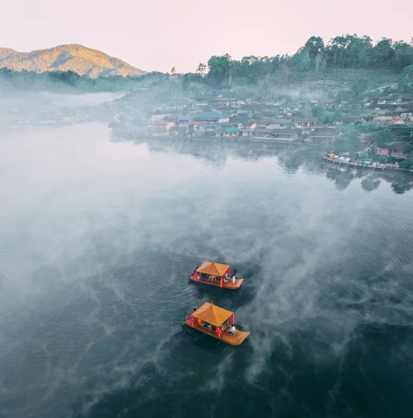 Ban Rak Thai 'de, Tayland' da Mae Hong Son 'da bir göl kenarındaki Çin köyünün üzerinde sisli gündoğumu manzarası.
