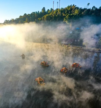 Ban Rak Thai 'de, Tayland' da Mae Hong Son 'da bir göl kenarındaki Çin köyünün üzerinde sisli gündoğumu manzarası.