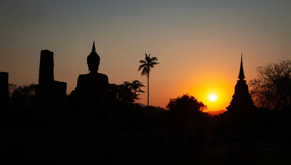 Pôr do sol em Wat Mahathat buddha e templo no Parque Histórico de Sukhothai — Fotografia de Stock