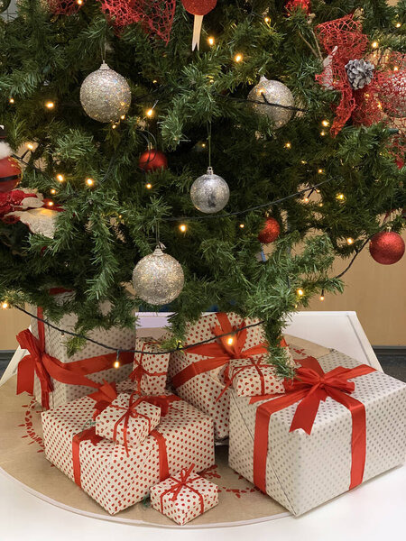 Рождественские подарочные коробки под елкой закрыть, новый год и рождественские праздники концепции