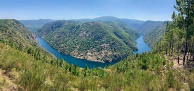 Dağlar arasında akan bir nehirde kıvrılıp, güzel bir doğal manzaranın panoramik bir fotoğrafı, Sil Kanyonu, İspanya