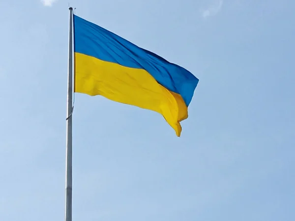 Oekraïense nationale vlag symbool fladdert in de blauwe lucht. — Stockfoto